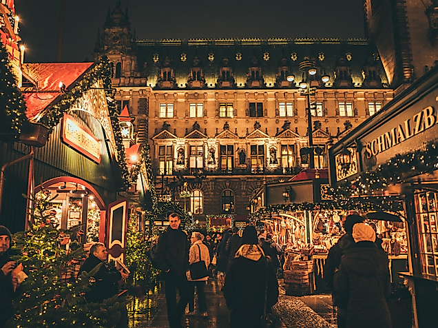 Illuminated Christmas market in the city center with festively decorated stalls and Christmas trees