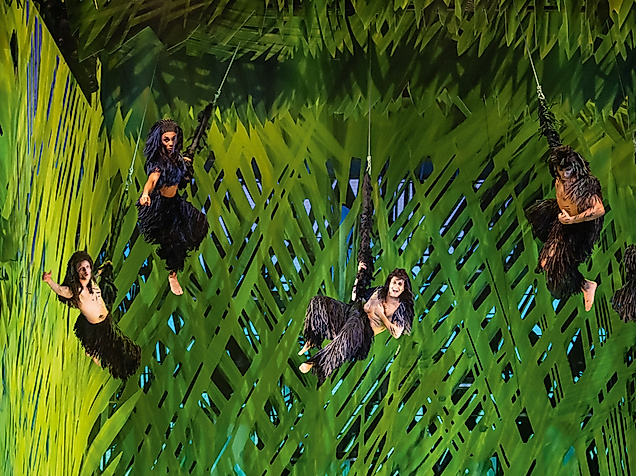 Szenenbild Musical Tarzan Menschen schwingen an Lianen vor Dschungehintergrund