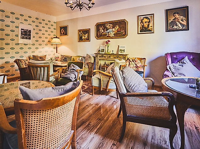 Verspielter Innenraum des Cafes Pauline mit Vintage-Möbeln, Blumen und Wandbildern.