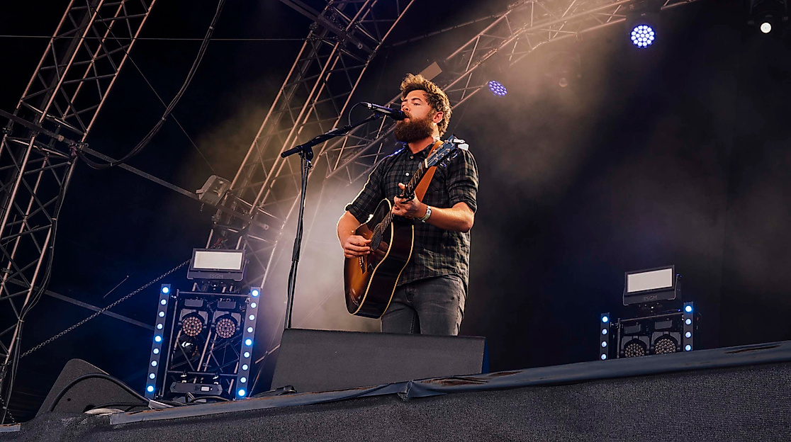 Gitarrist auf Open-Air-Bühne im Scheinwerferlicht