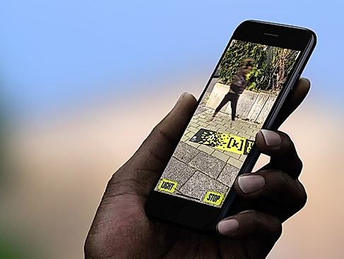 Eine Grafik von einer Hand, die ein handy in der Hand hat. Auf dem Bildschirm ist ein Gelände.