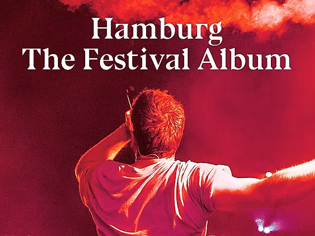 Person mit Bengalo in rotem Licht bei Musikveranstaltung. Text: Hamburg The Festival Collection.