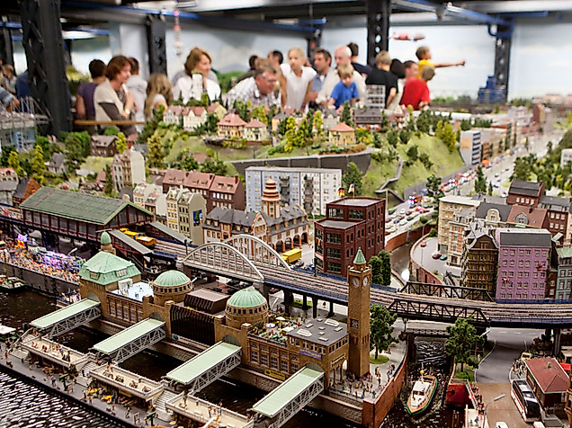 Besucher:innen bestaunen detailreiche Modelllandschaften mit Zügen und Stadtszenen im Miniatur Wunderland Hamburg