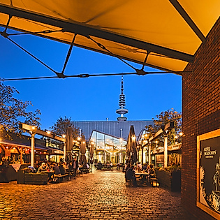 Abendstimmung vor dem Brauhaus Altes Mädchen in Hamburg mit Lichterketten, Ziegelwänden und Blick auf den Fernsehturm