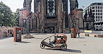 Rikscha mit Fahrgästen vor der Ruine der St.-Nikolai-Kirche im Zentrum von Hamburg
