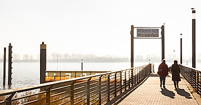 Spaziergänger:innen auf dem Anleger Willkomm Höft in Hamburg mit Blick auf die Elbe