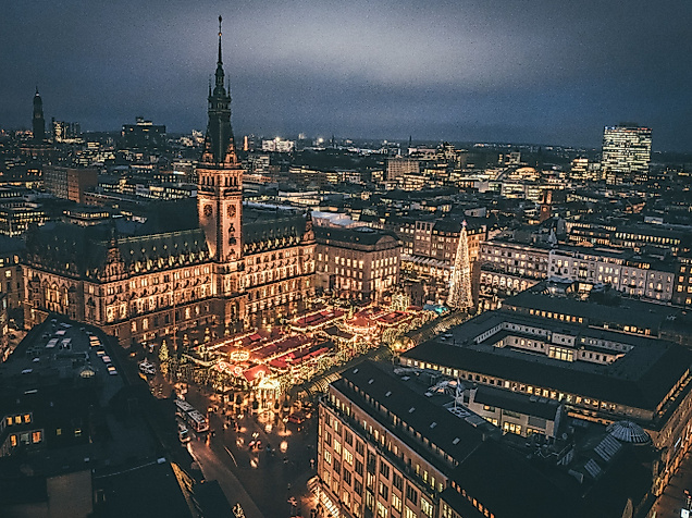 Luftaufnahme der festlich beleuchteten Hamburger Innenstadt mit Weihnachtsmarkt am Rathaus bei Nacht