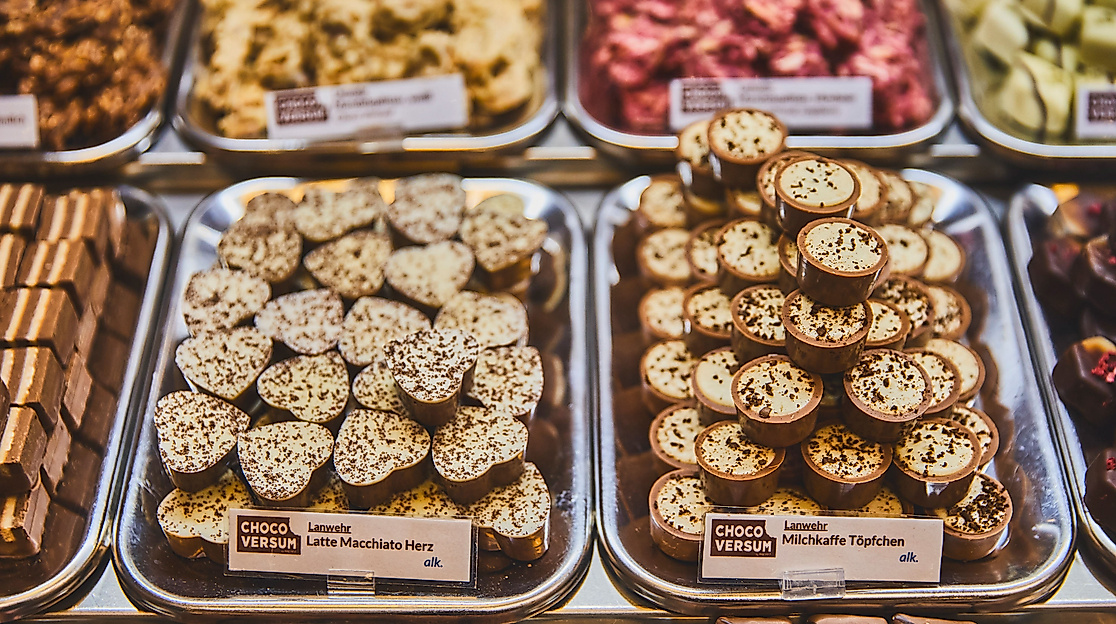 Auswahl an handgefertigten Pralinen in der Confiserie des Chocoversums Hamburg, appetitlich auf Tabletts präsentiert