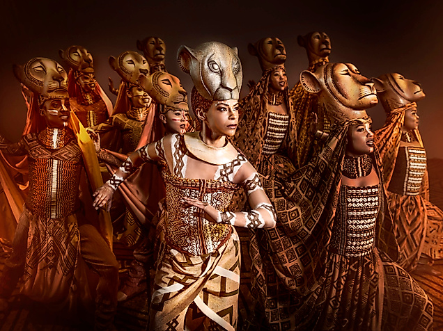 König der Löwen: Person in Löwenkostüm mit großer Maske steht in dynamischer Pose