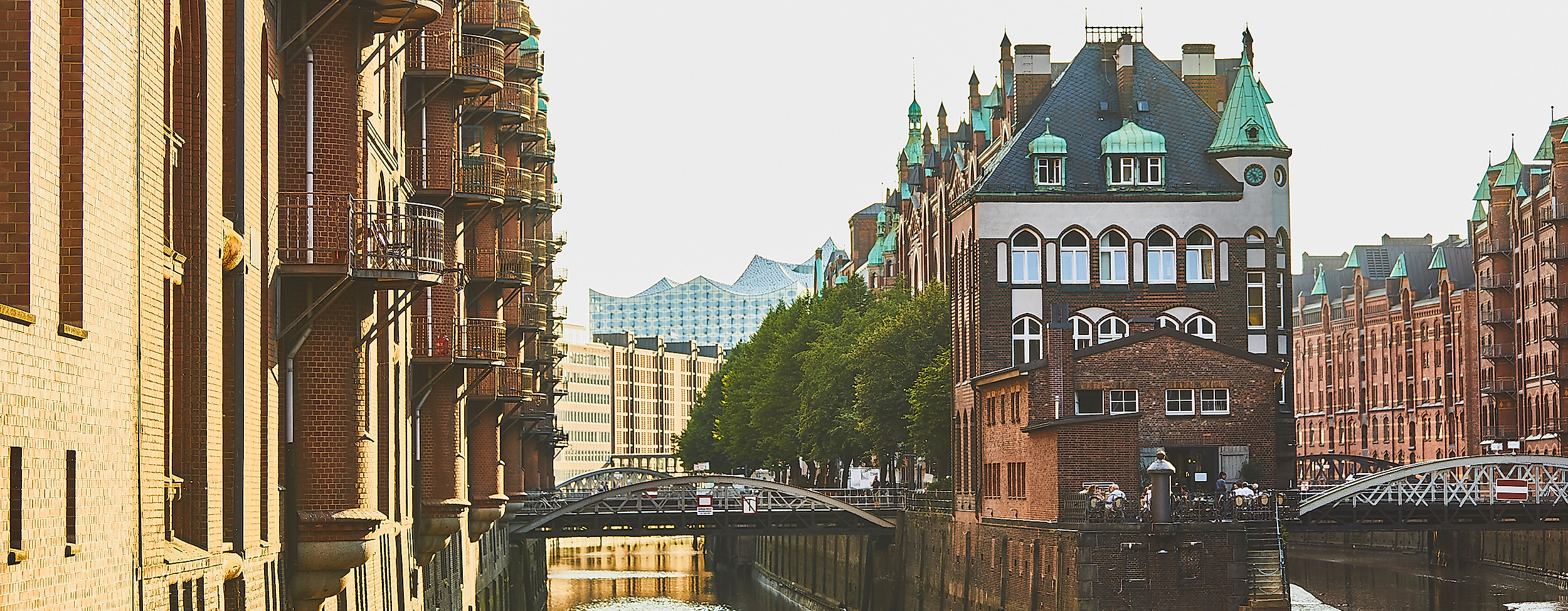 Wasserschloss in der Speicherstadt im warmen Licht der Abendsonne, flankiert von historischen Lagerhäusern