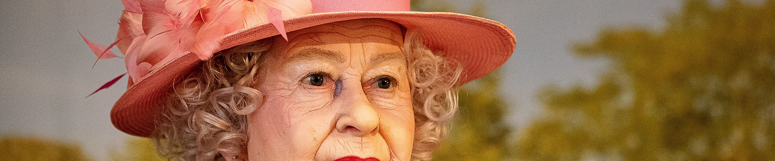 Wachsfigur von Queen Elizabeth II. mit rosa Hut als britisches Kultursymbol in Hamburg