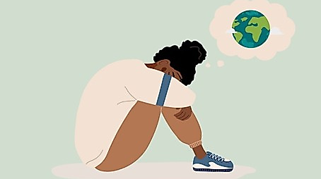 Auf dem Boden hockende Person, die sich sorgenvolle Gedanken um die Welt macht.