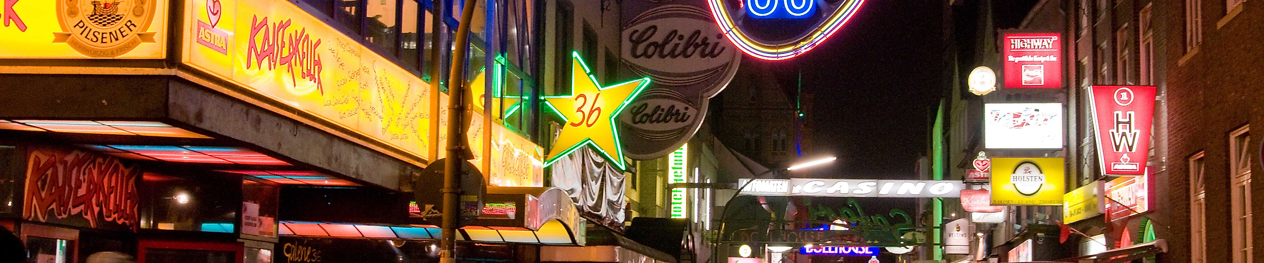 Belebte Große Freiheit bei Nacht mit leuchtenden Clubschildern und Gitarren-Neonreklame