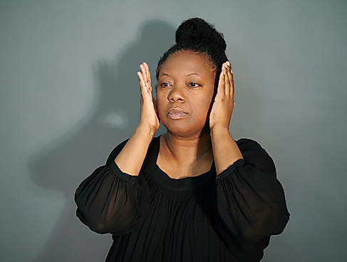 Nachdenkliche Pose vor grauem Hintergrund