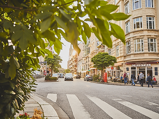 Belebte Straßenszene im Portugiesenviertel mit Restaurants und Altbaufassaden an einem sonnigen Tag
