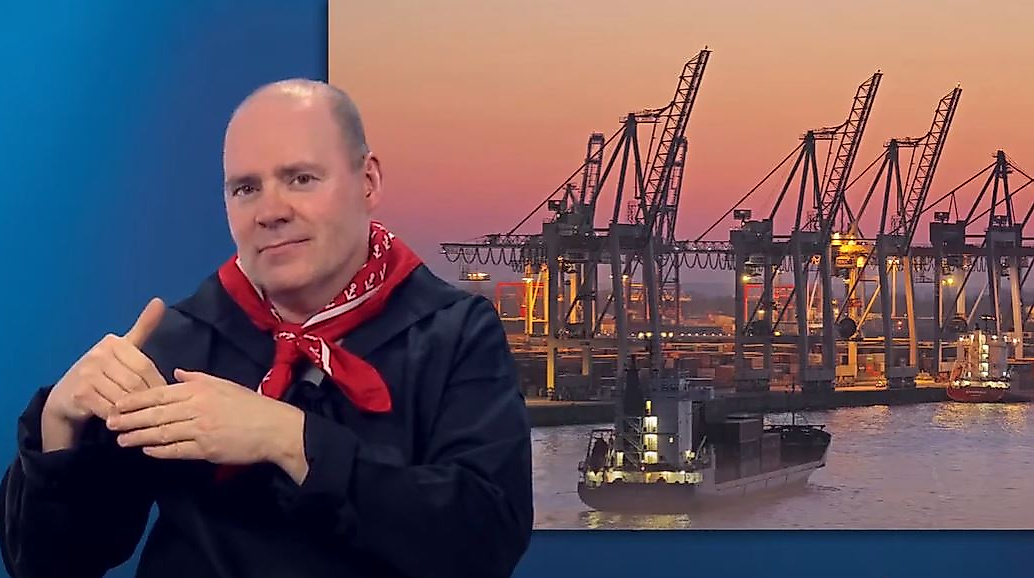 Mann gebärdet vor Panorama des Hamburger Hafens bei Sonnenuntergang – barrierefreie Infos zum Hafenleben.