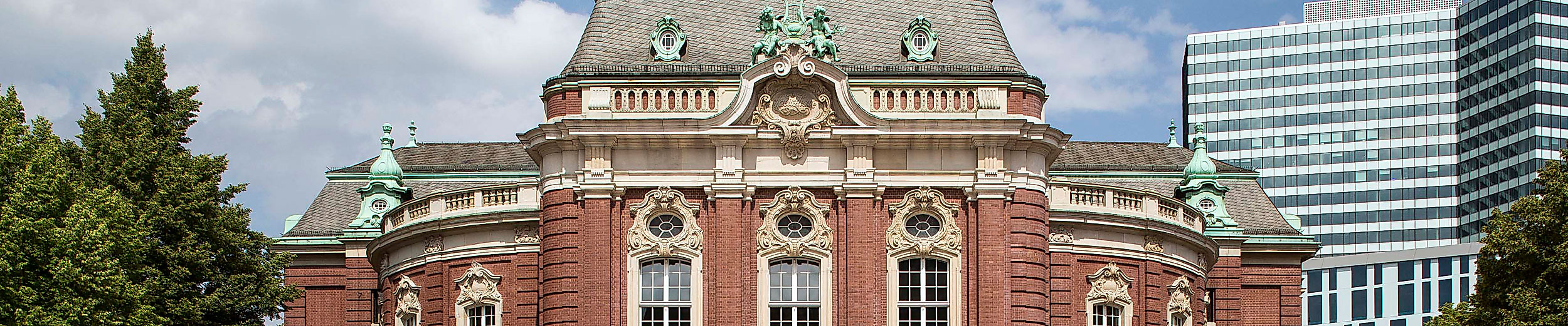 Frontansicht der Laeiszhalle in Hamburg mit historischem Kuppeldach und modernen Gebäuden im Hintergrund