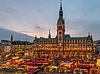 Weihnachtsmarkt auf dem Rathausmarkt vor dem festlich beleuchteten Hamburger Rathaus in der Dämmerung