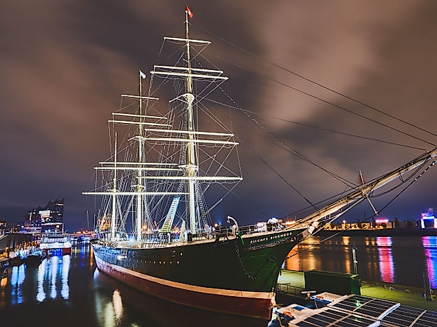 Das beleuchtete Museumsschiff Rickmer Rickmers liegt nachts im Hamburger Hafen vor illuminiertem Himmel