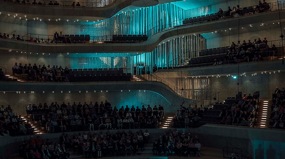 Beleuchteter Konzertsaal der Elbphilharmonie mit Orchester und Publikum beim InterMusikfest.