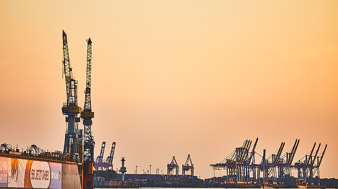 Hafendocks im Hamburger Hafen bei Sonnenuntergang mit Silhouetten von Containerkränen
