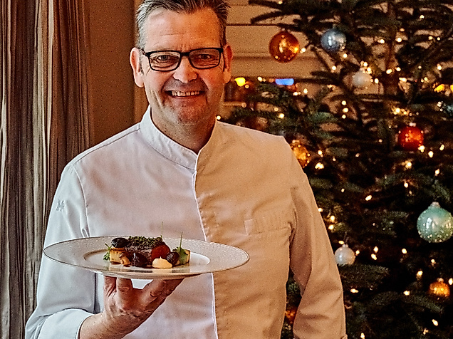 Spitzenkoch Thomas Martin serviert festliches Weihnachtsgericht vor Christbaum im Louis C. Jacob Hamburg