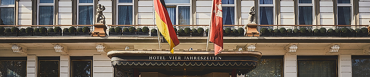 Eingang des Hotel Vier Jahreszeiten Hamburg mit Flaggen und Doorman als Symbol internationaler Gastkultur