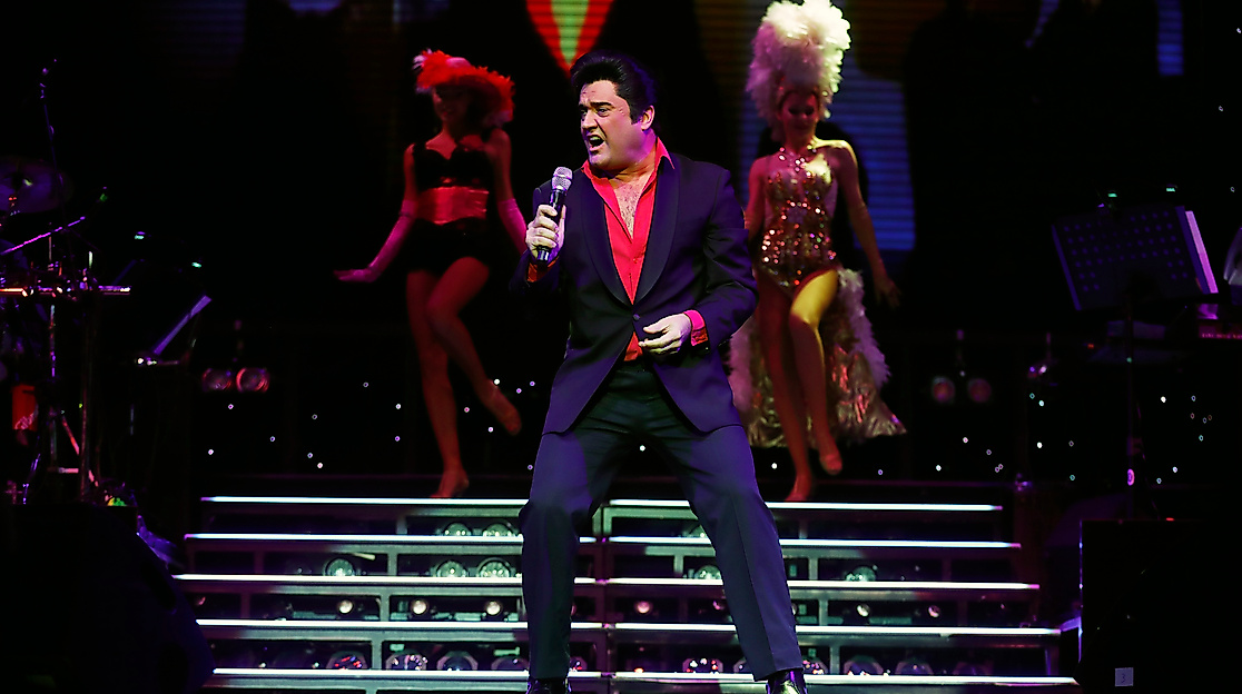 Bühnenbild mit Elvis Presley Darsteller im Vordergrund und Background Band im Hintergrund