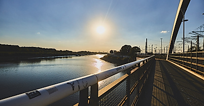 Sonnenuntergang über dem Veddeler Spreehafen, gesehen von einer Brücke mit Blick auf Wasser und Ufer