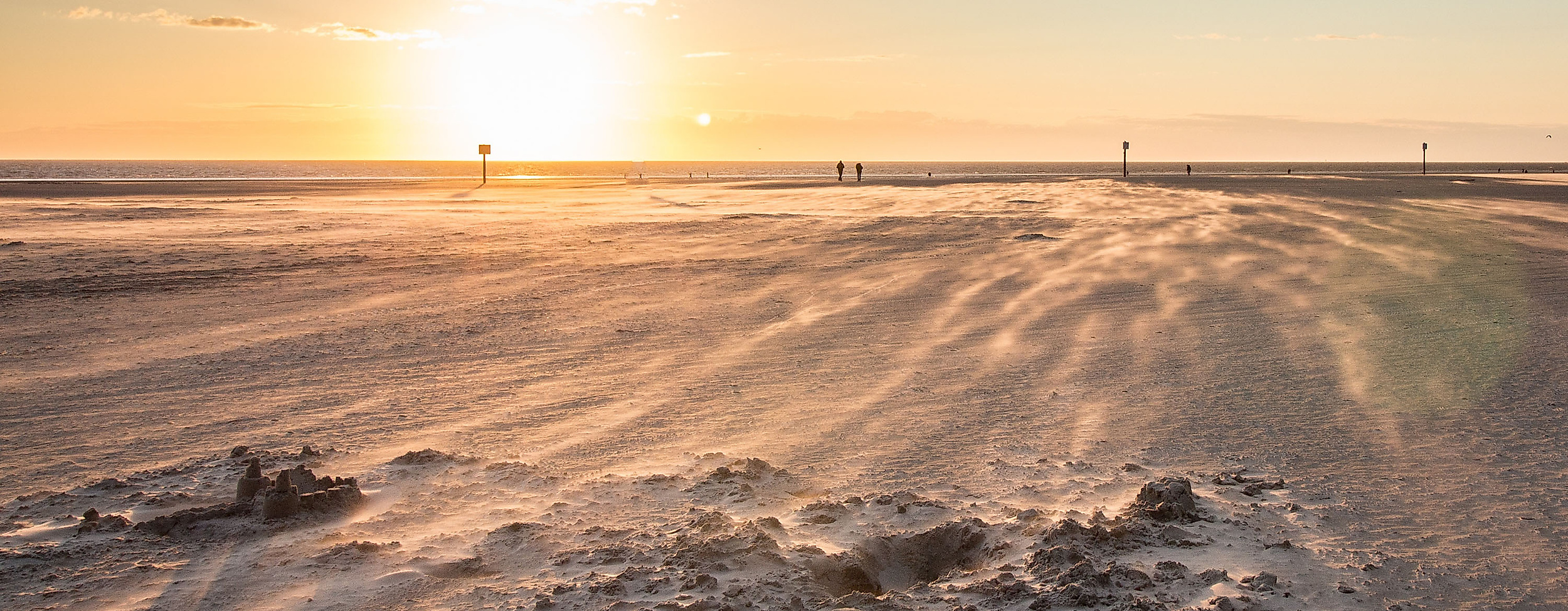 Weitläufiger Nordseestrand im Sonnenuntergang mit Wattlandschaft – Ausflugsziel ab Hamburg