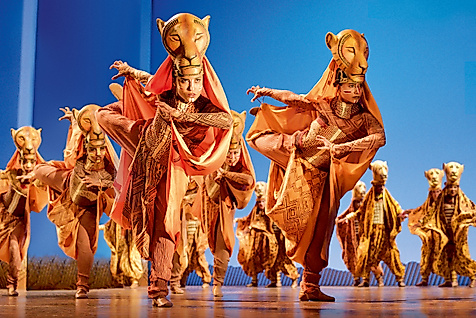 A scene from Disney's musical The Lion King with costumed lionesses dancing.