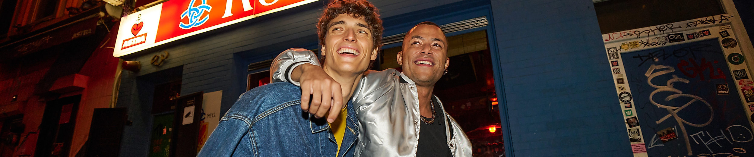 Zwei Männer Arm in Arm auf dem Hamburger Berg vor einer Kneipe