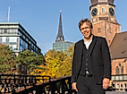 Pastor Frank Engelbrecht auf Brücke in Hamburg mit Blick auf Hauptkirche St. Katharinen und moderne Architektur