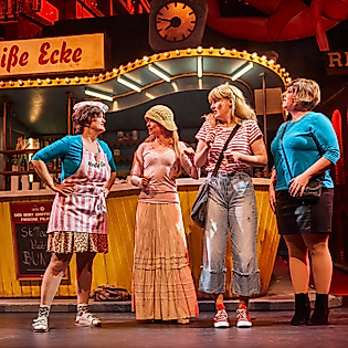 Szenenbild Heiße Ecke: Vier Darsteller:innen schauen zueinander