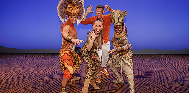 Annemarie und Wayne Carpendale posieren mit zwei Darstellern von Disneys König der Löwen