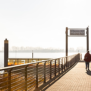 Spaziergänger:innen auf dem Anleger Willkomm Höft in Hamburg mit Blick auf die Elbe