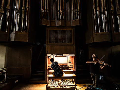Stefan  Rusconi sitzt an der Orgel, neben ihm steht Tobias Preisig und spielt auf der Violine.