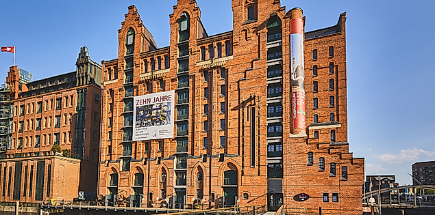 Backsteingebäude des Internationalen Maritimen Museums mit Banner und Brücke in der Hamburger Speicherstadt.