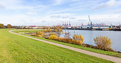 Grünanlage am Südufer der Elbe mit Blick auf Containerhafen und Hafenkräne in Hamburg-Harburg