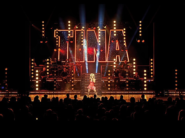 Tina Turner performt auf einer Musical Bühne mit Menschen im Publikum