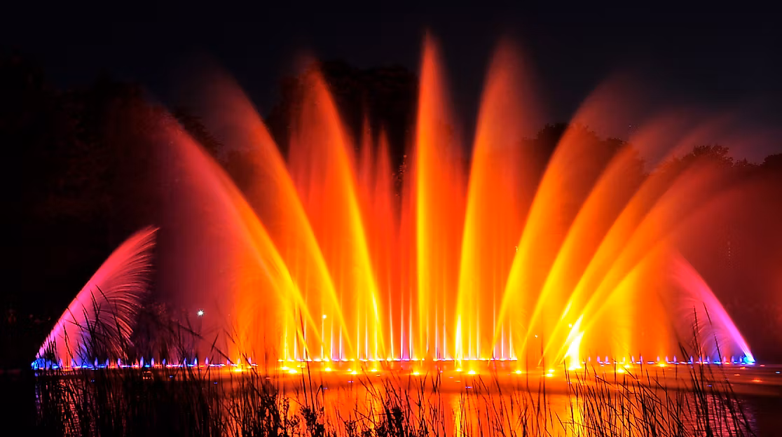 Farbig beleuchtete Wasserfontänen der Wasserlichtspiele in Planten un Blomen bei Nacht