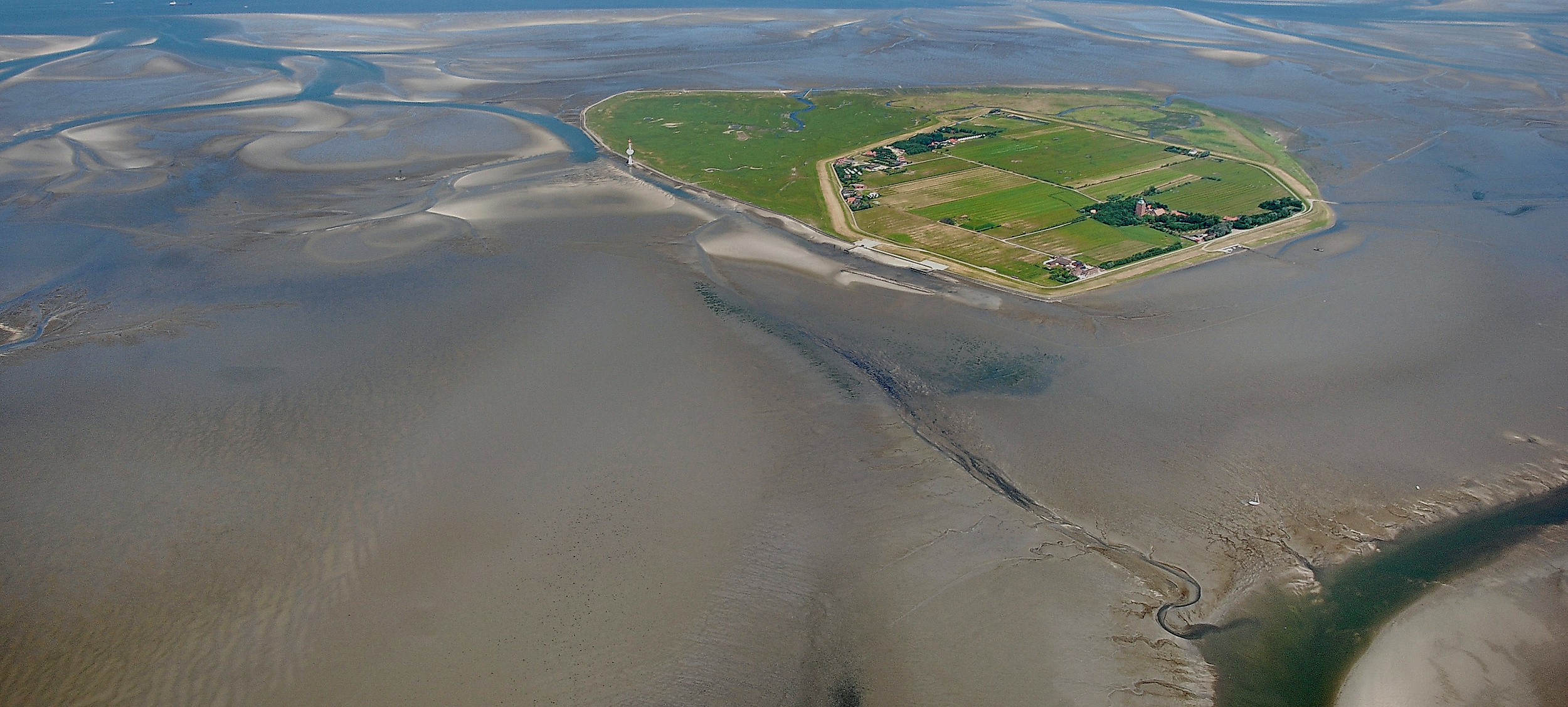 Luftaufnahme der Hallig Neuwerk im Wattenmeer bei Ebbe mit grüner Inselmitte und umliegenden Prielen