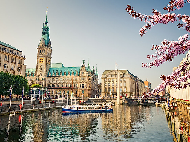 Aktivitäten im Frühling in Hamburg Kirschblüte Rathaus mit Boot im Vordergrund