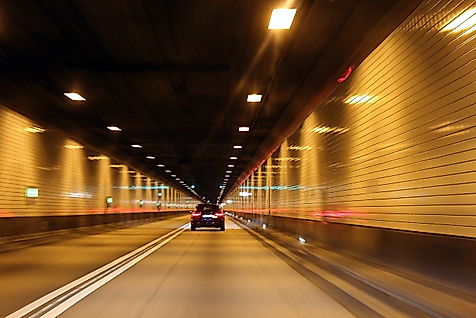 Auto fährt im Elbtunnel beleuchtet von gelben Lichtern