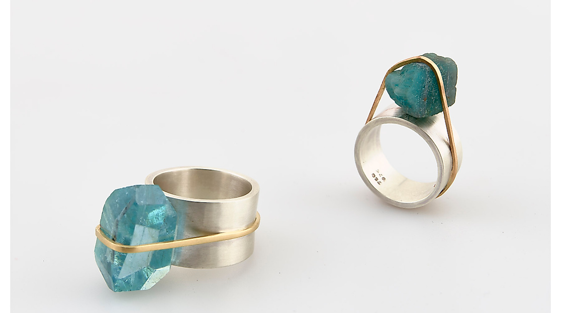 Die Künstlerin Silke Spitzer widmet sich ihrem Thema Edelsteine in Form von Halsketten, hat jetzt aber auch so genannte „Bündelringe“ – hier mit Aquamarin, Silber und Gelbgold – entworfen.