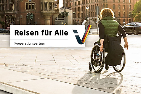  Rollstuhlfahrerin unterwegs in der Speicherstadt, daneben Logo „Reisen für Alle“ für zertifizierte Barrierefreiheit.