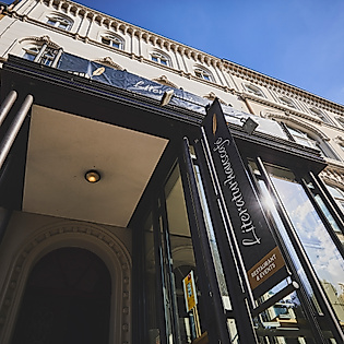 Eingangsportal des Literaturhauses Hamburg mit Jugendstilfassade und schmiedeeisernem Tor unter blauem Himmel