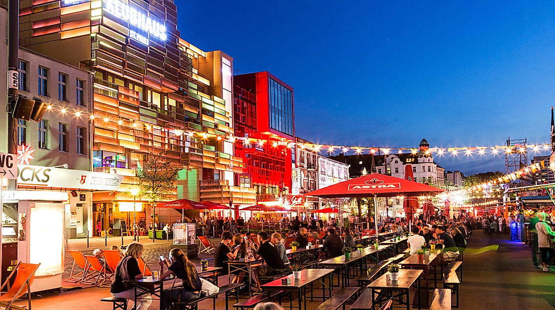 Abendstimmung beim Reeperbahn Festival in Hamburg mit Lichterketten, Straßencafés und vielen Besucher:innen.