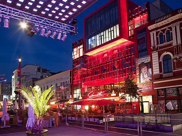 Beleuchtetes Schmidt Theater auf der Reeperbahn bei Nacht, umgeben von Bars und Lichtinstallationen