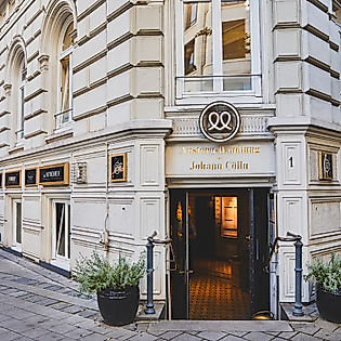 Eingang des Restaurants Cöllns Mutterland in historischem Gebäude mit heller Fassade in Hamburg.